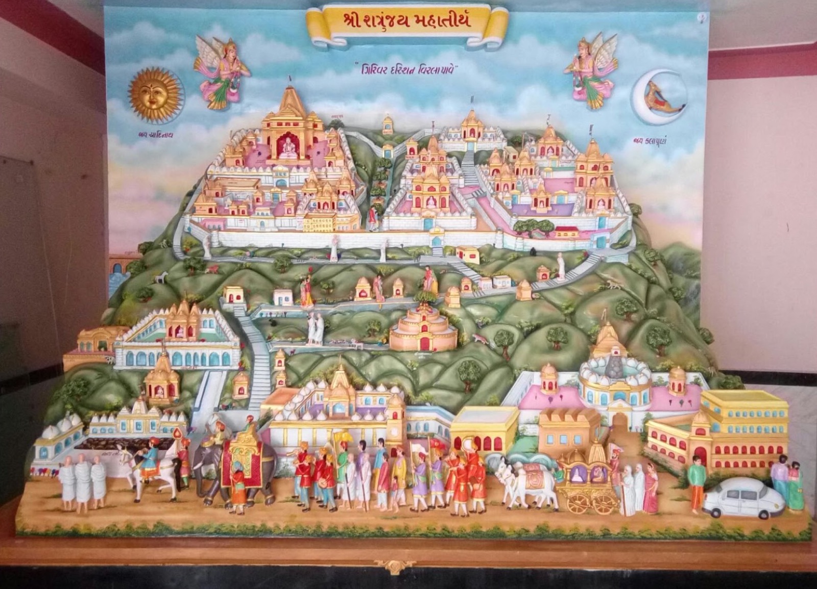 Painted polychrome relief of the Shatrunjay hill temples at Palitana, with a pilgrim procession below